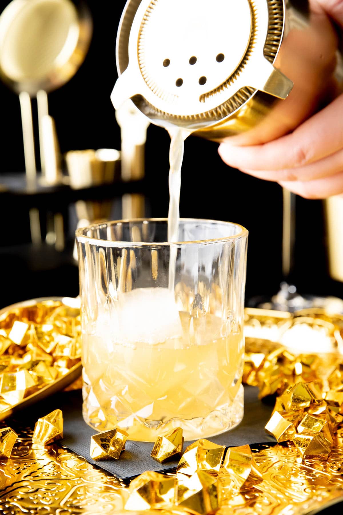 close up showing the Gold Rush Cocktail Recipe strained into a glass filled with ice