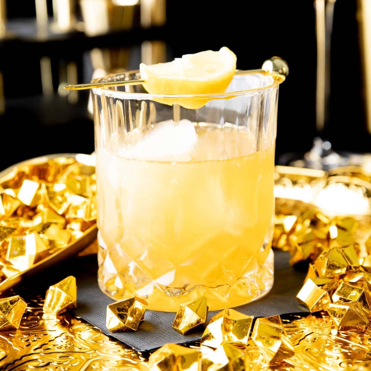 Gold Rush Cocktail served in a crystal rocks glass with gold nuggets