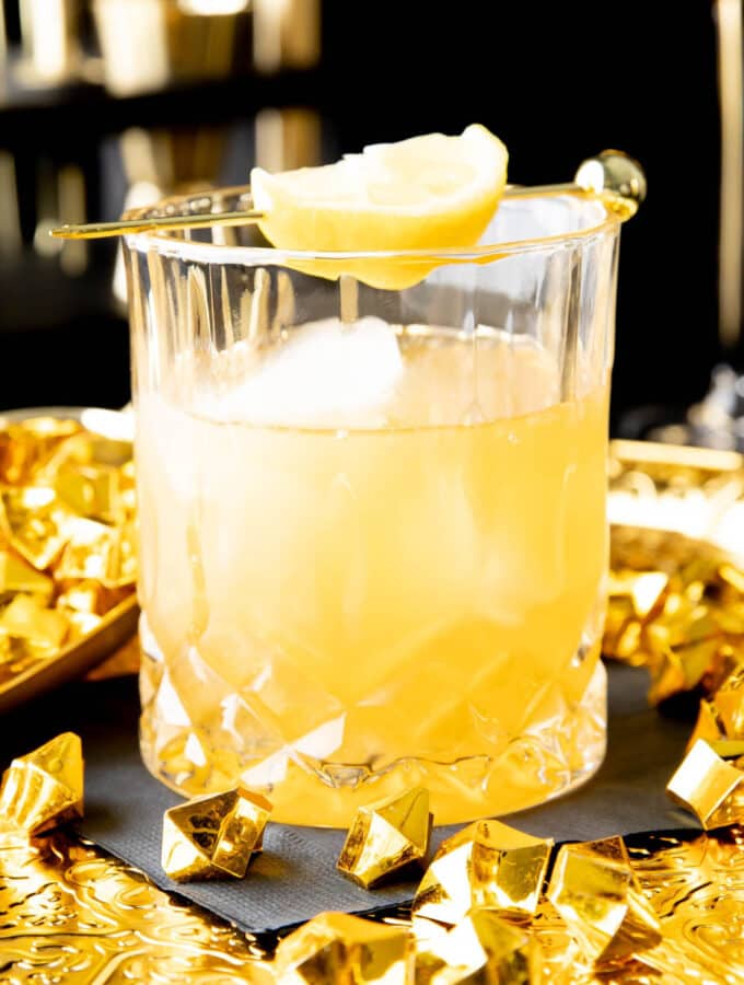Gold Rush Cocktail served in a crystal rocks glass with gold nuggets