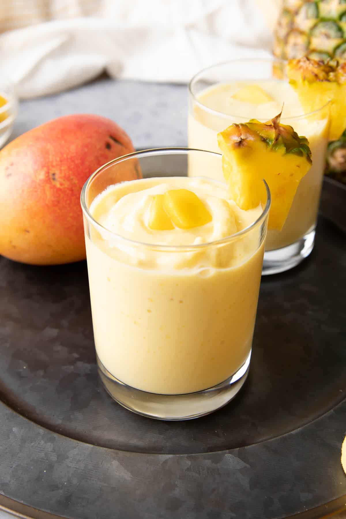 Mango Pineapple Smoothie in a glad with pineapple garnish