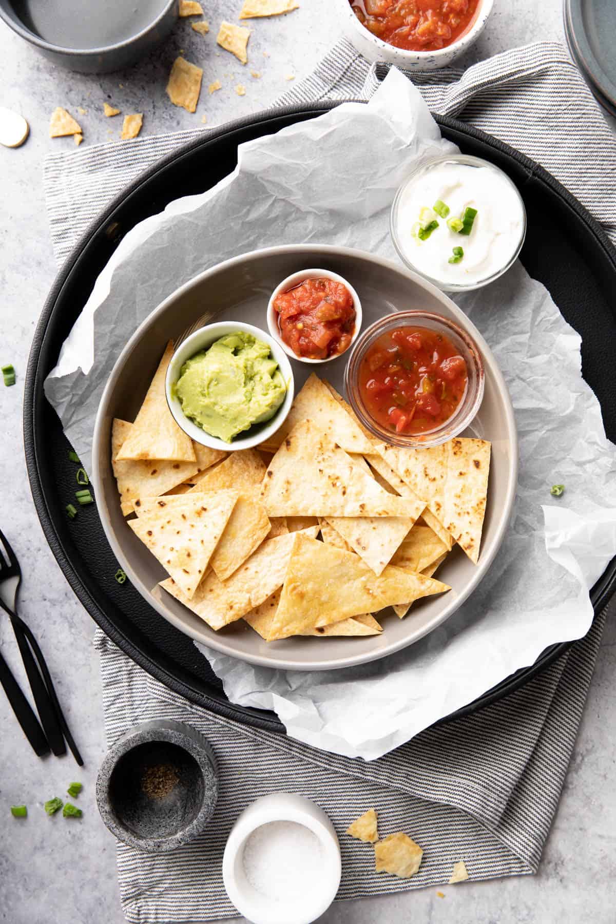 Mexican-inspired dinner table with guacamole, salsa, sour cream, and utensils