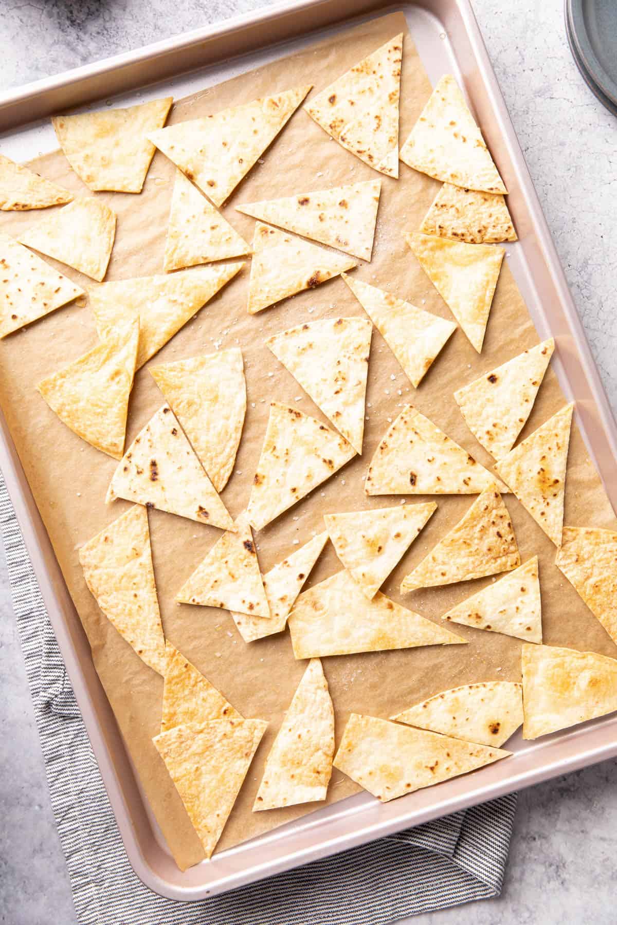 Fully baked tortilla chips on baking sheet