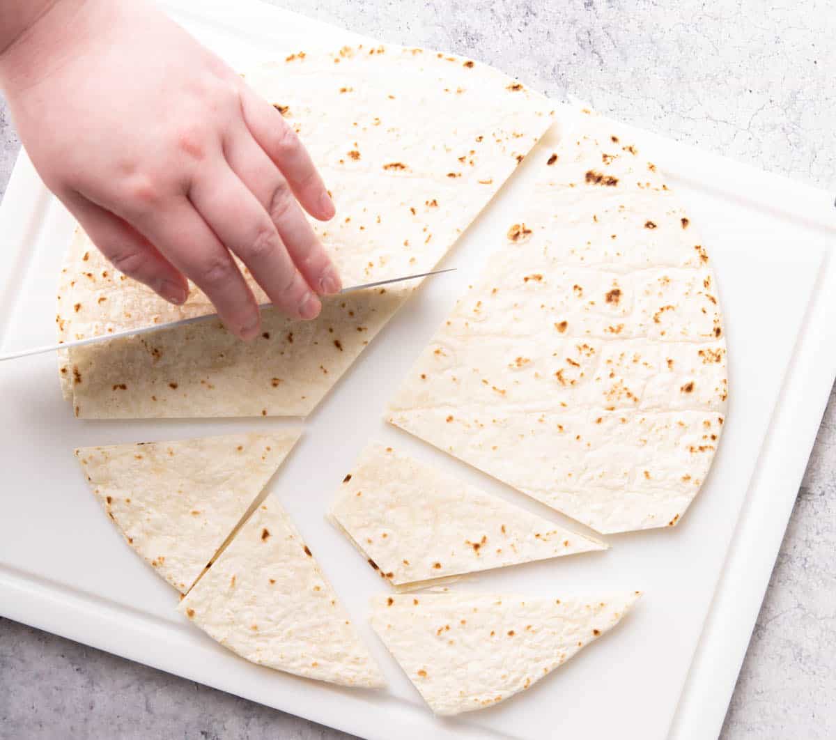 Photo showing How to Make Baked Tortilla Chips – slicing tortillas into chips