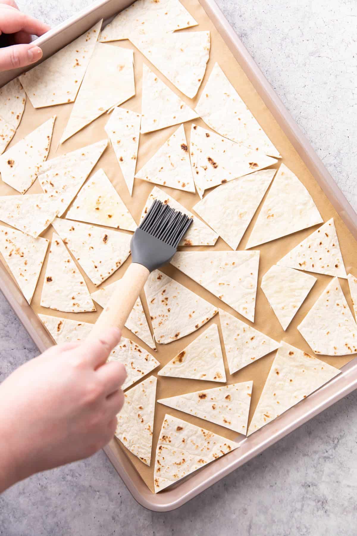 Photo showing How to Make this recipe – brushing oil onto chips