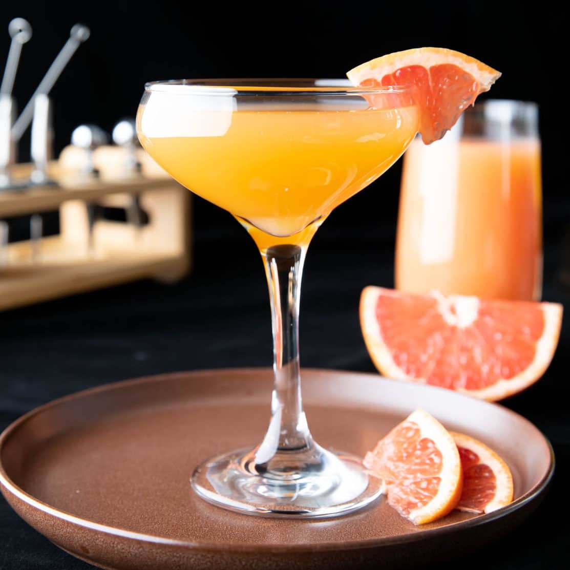 this drink recipe in a glass with a grapefruit garnish
