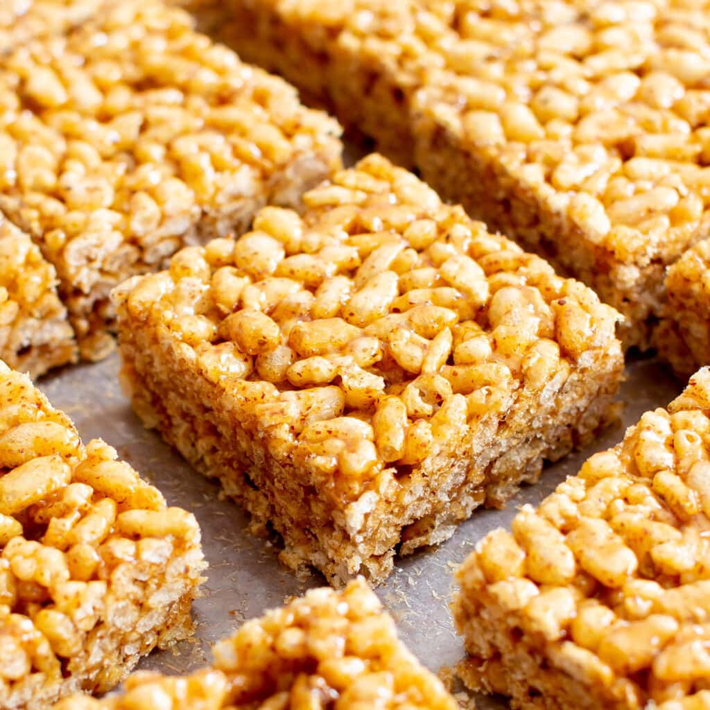 Healthy rice crispy treats spread out on parchment paper