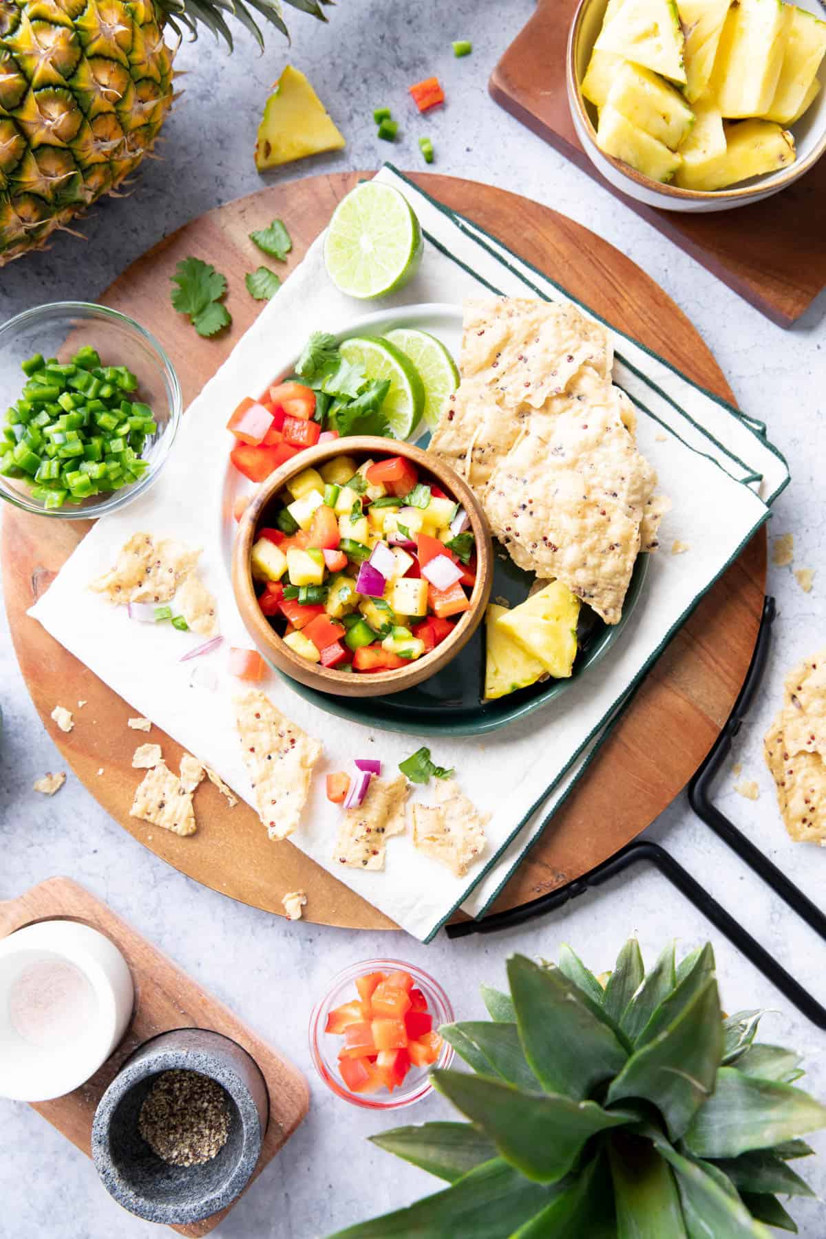 Sliced limes, pineapple wedges, and tomatoes served with a bowl of pineapple salsa and tortilla chips