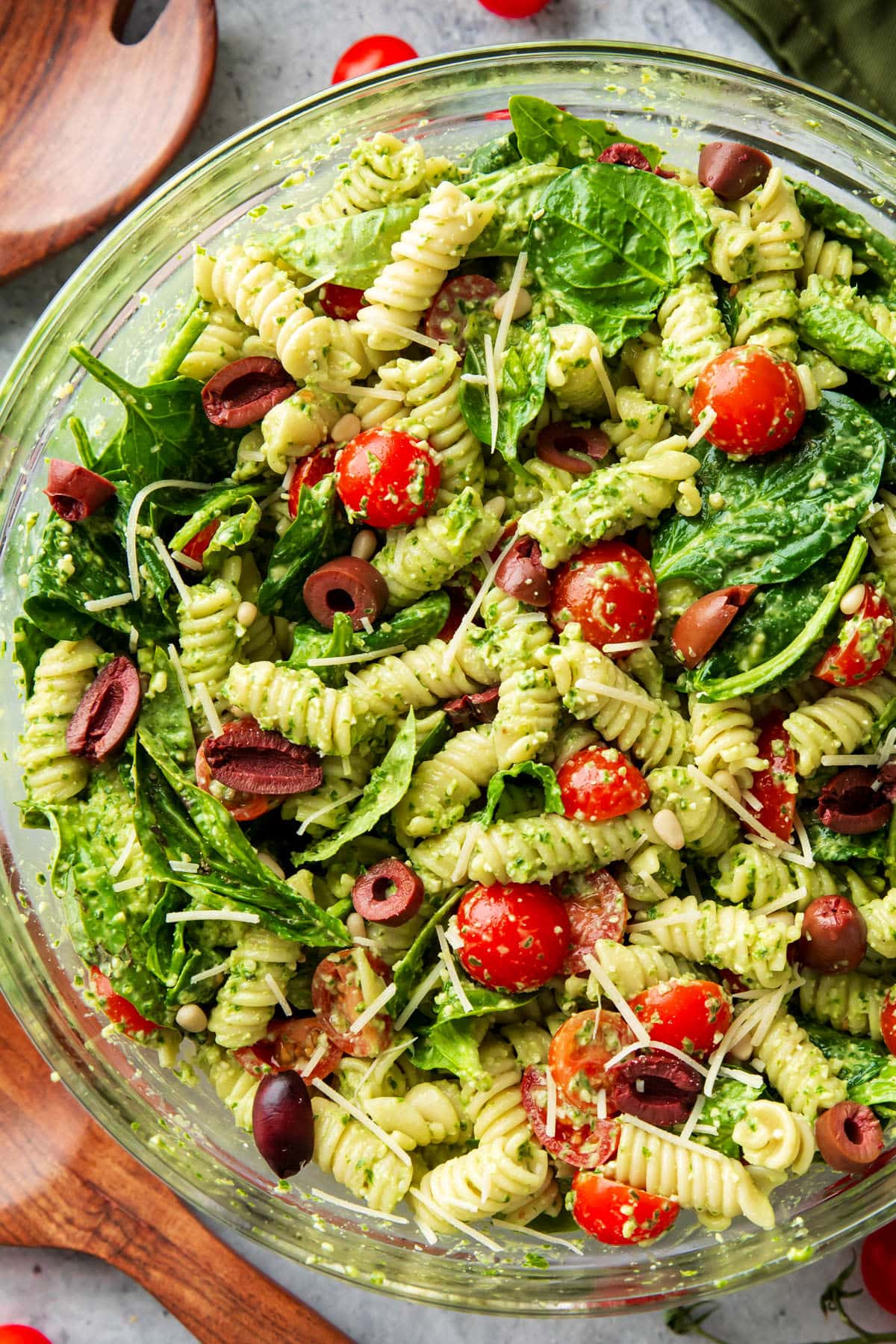 Pasta Salad with pesto sauce is served in a large glass mixing bowl.