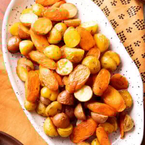 Roasted carrots and potatoes are oven-roasted until tender and served on a Thanksgiving table