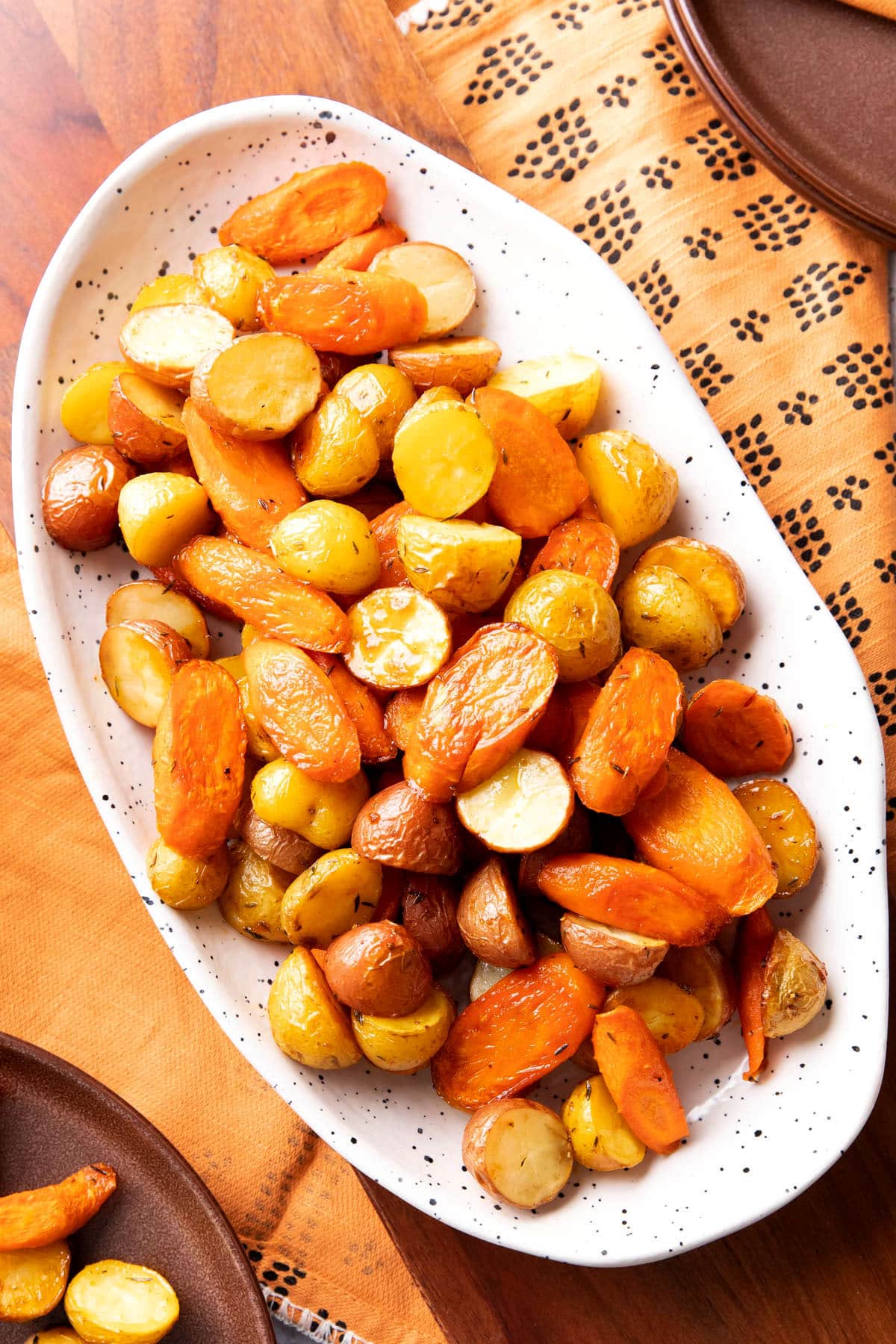 Roasted carrots and potatoes are oven-roasted until tender and served on a Thanksgiving table