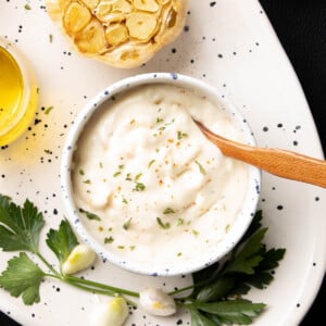 Roasted Garlic Aioli in a bowl with a wooden spoon