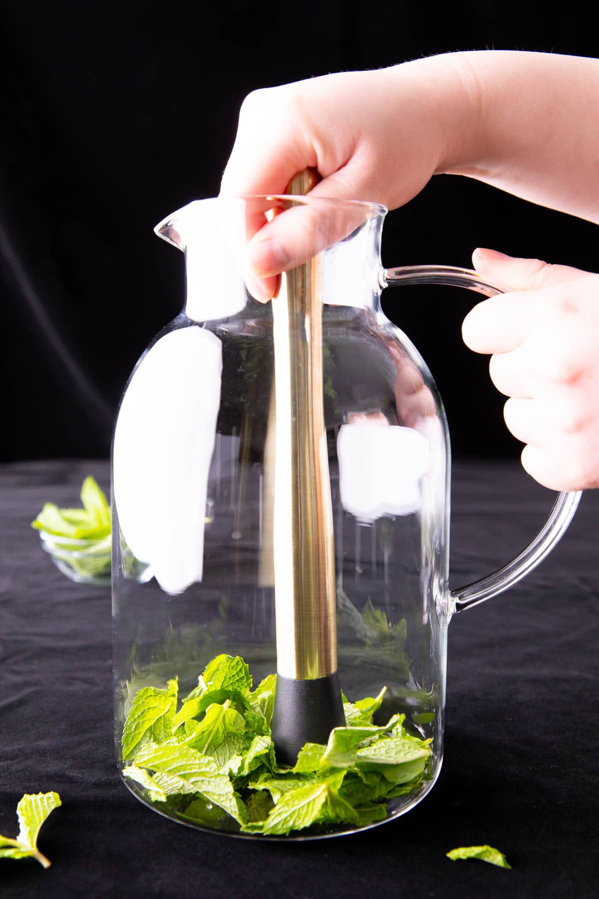 Two photos showing How to Make Mint Water – muddling the mint
