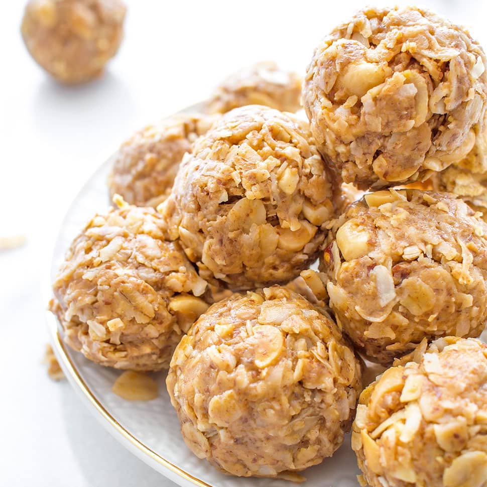 Gold rimmed plate with stack of peanut butter coconut energy balls on top