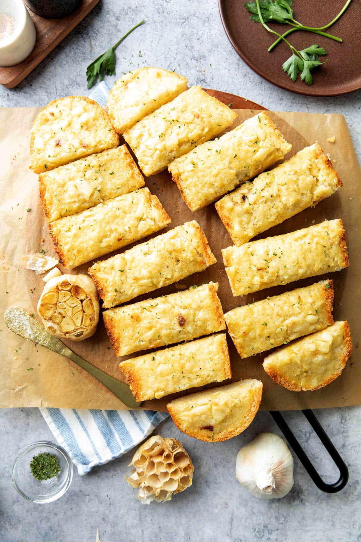 Roasted Garlic Bread is baked and sliced on a serving board with garlic butter.