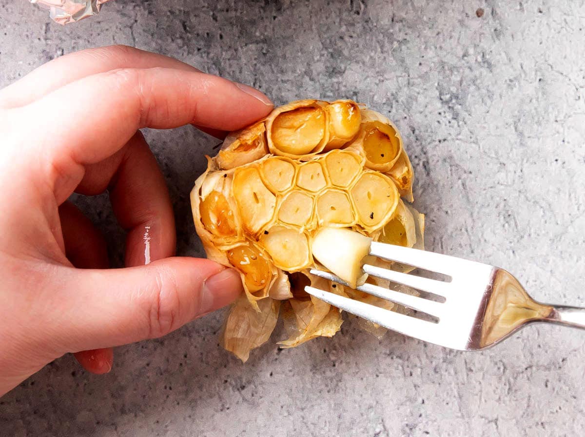 Pulling roasted garlic cloves out of shell after roasting.