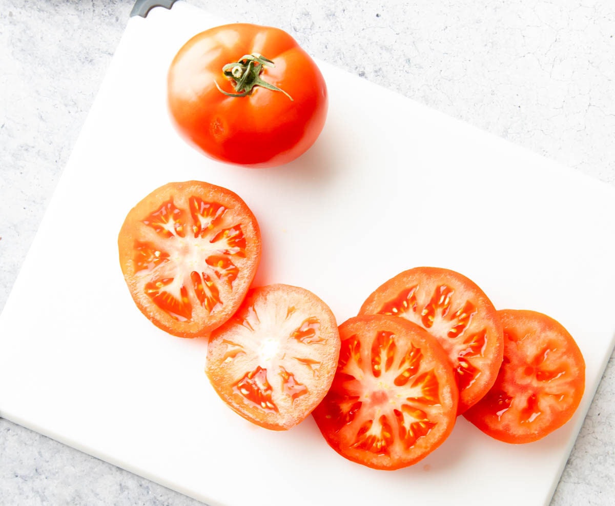 Slices of tomatoes spread across a cutting board