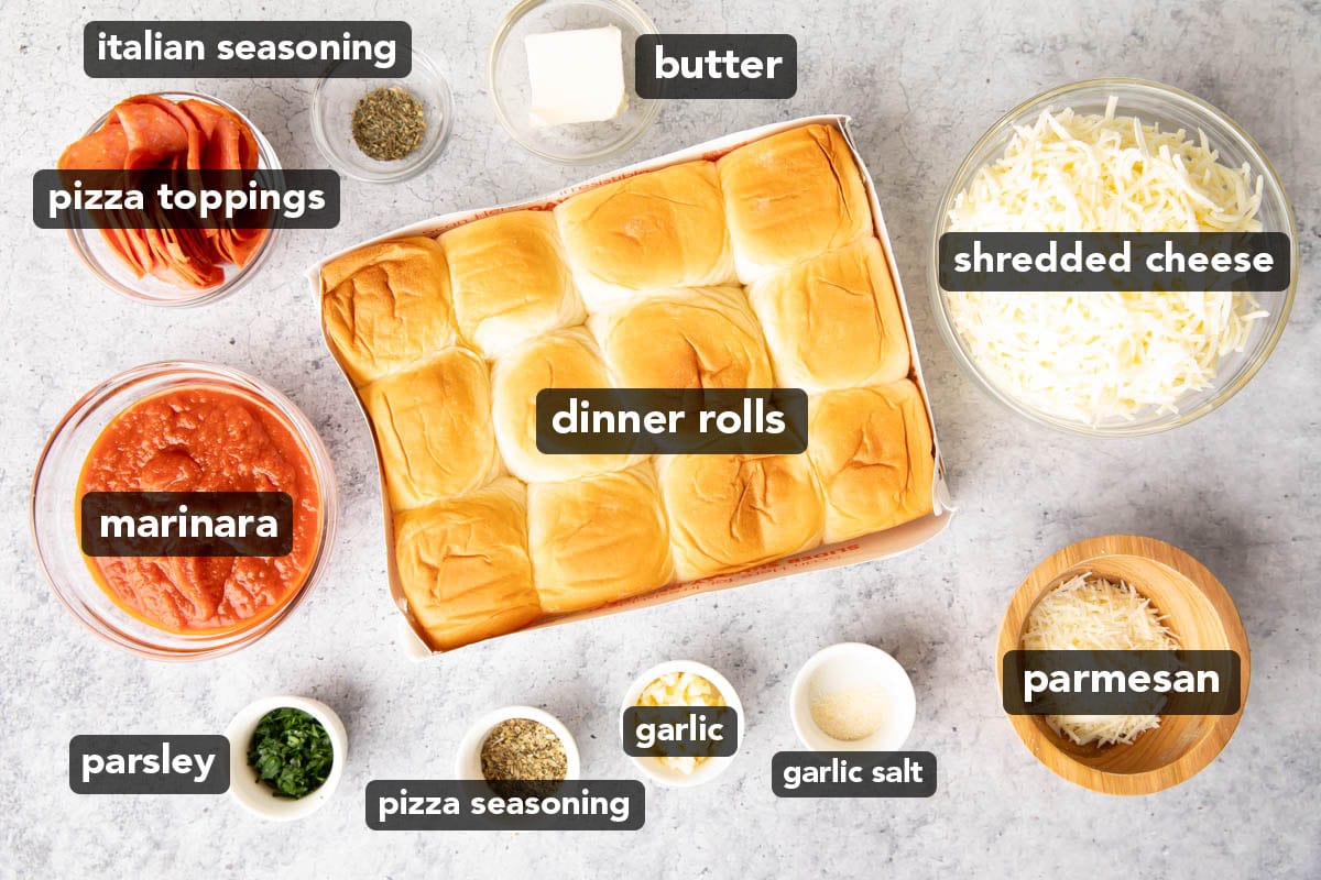 Pizza slider ingredients measured in prep bowls, including pizza seasoning, Hawaiian rolls, cheese, pepperoni, butter, parmesan, and minced garlic