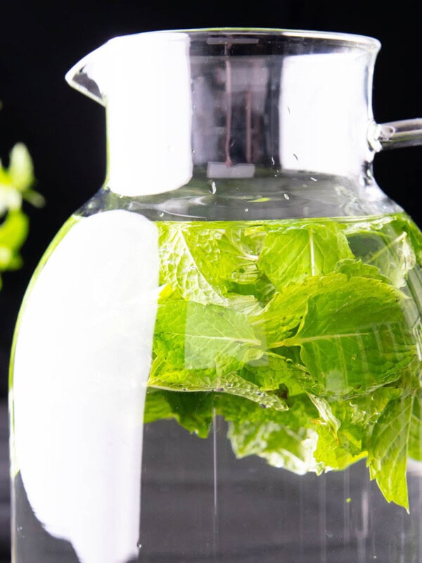 close up of mint water pitcher against a black background