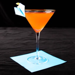 Paper Plane cocktail in a cocktail glass served with an origami paper plane