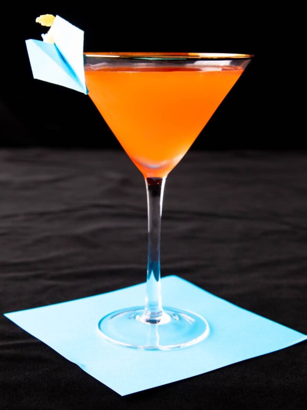 Paper Plane cocktail in a cocktail glass served with an origami paper plane