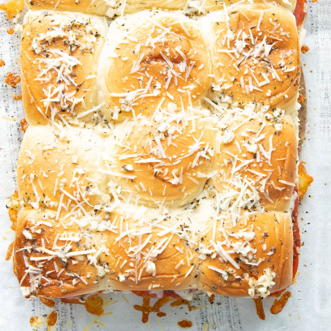 Close up of parmesan, butter, garlic, and seasonings baked onto the top layer of this Italian recipe