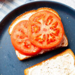 thick tomato slices on top of mayo over bread for a Tomato Sandwich