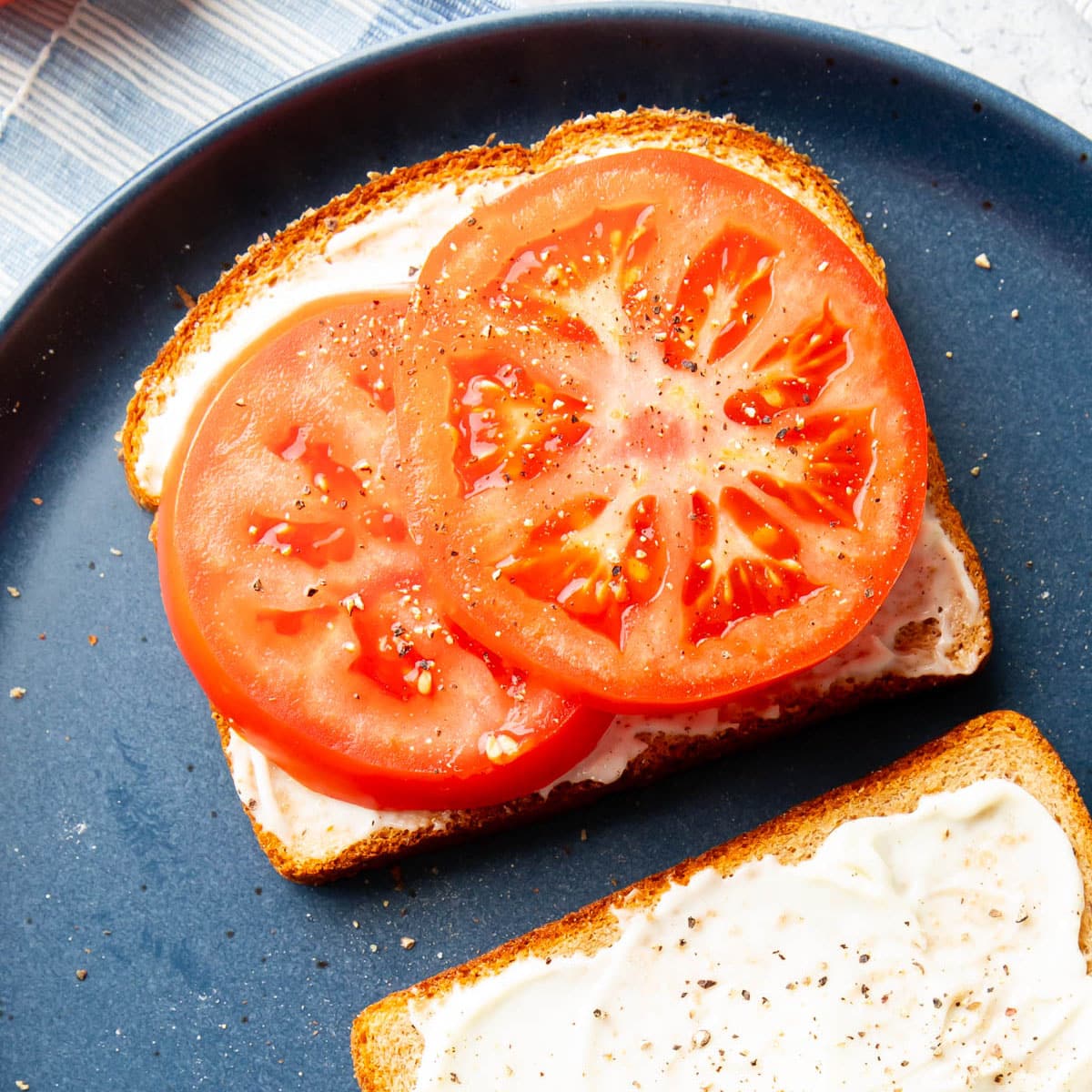 thick tomato slices on top of mayo over bread for a Tomato Sandwich