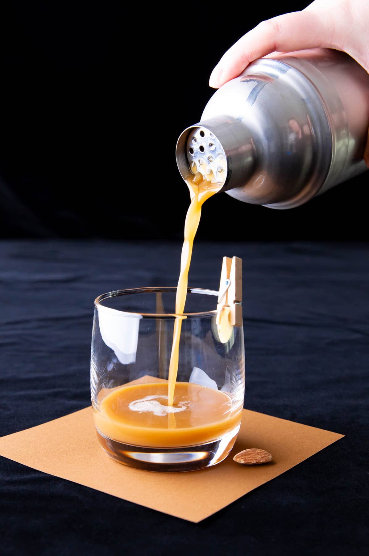 Zdjęcie pokazujące sposób przygotowania napoju z prażonych migdałów – przecedzenie mieszanki koktajlowej do shakera