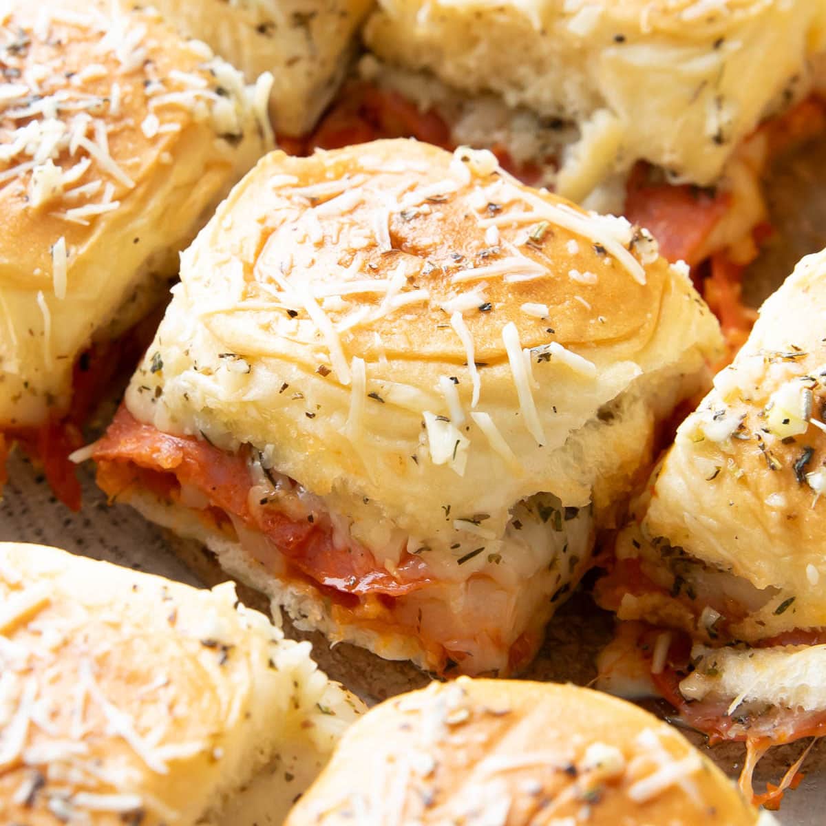 Pizza Sliders with melting cheese, zesty pepperoni, and butter topping