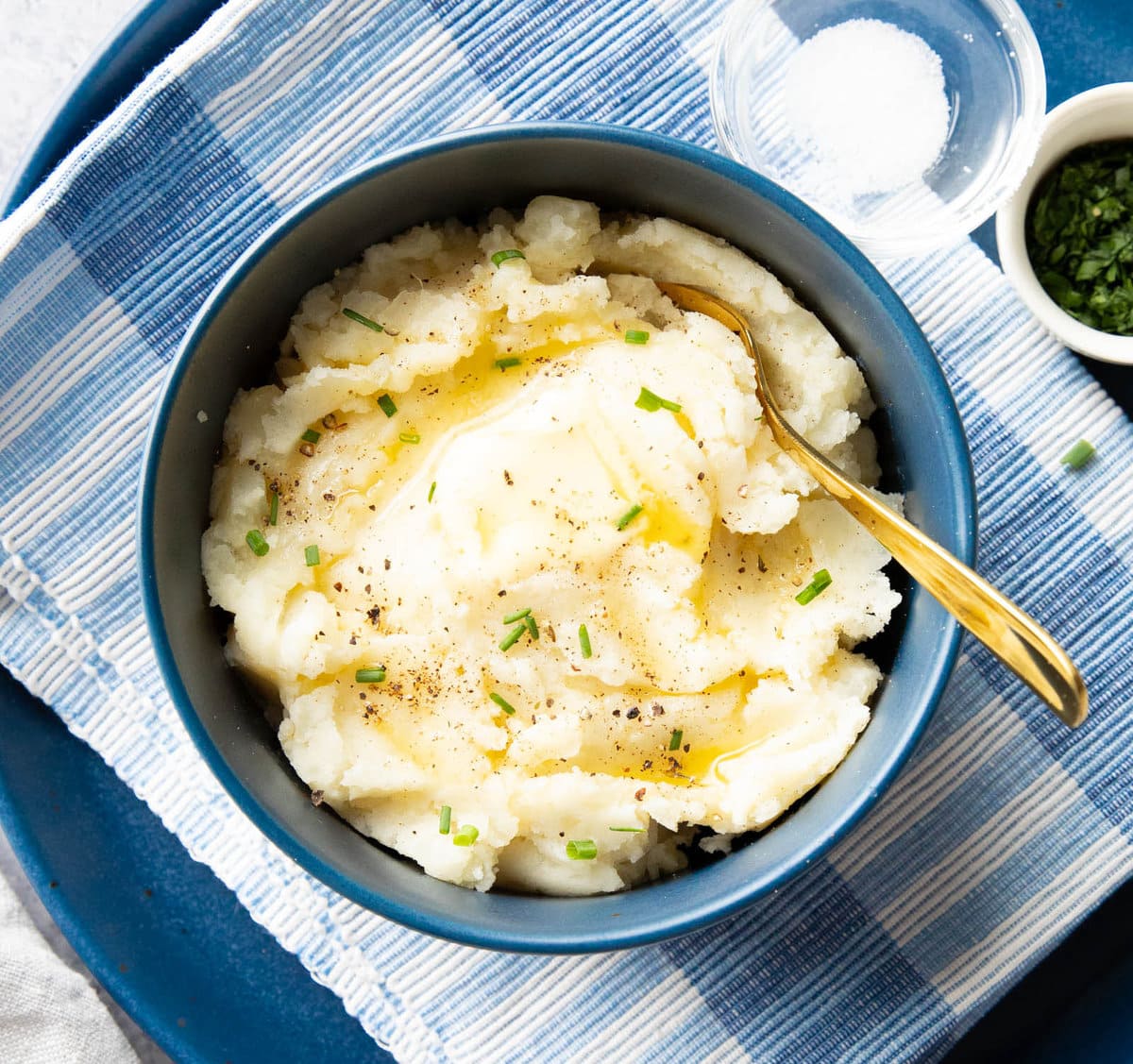 Vegan mashed potatoes served in a bowl topped with butter and chives