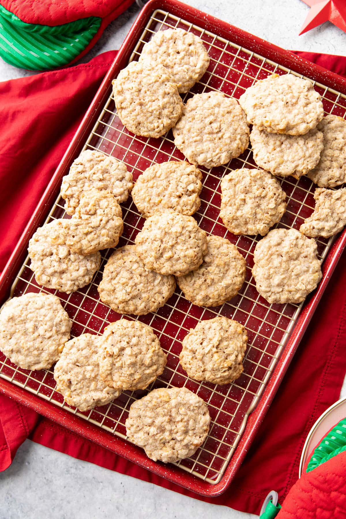 Cinnamon Oatmeal Cookies on a cooling rack tucked into a baking sheet with festive red decorations
