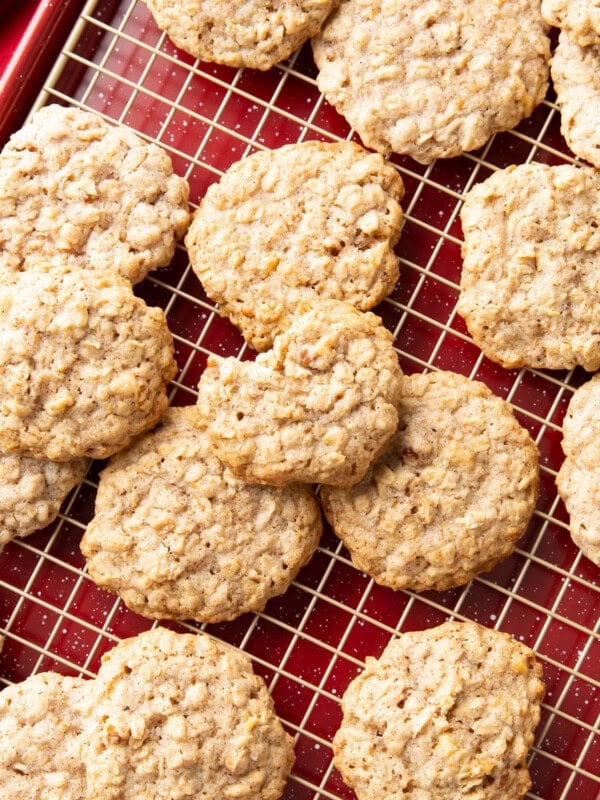 Cinnamon Oatmeal Cookies on a cooling rack tucked into a baking sheet with festive red decorations