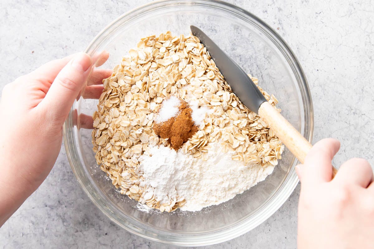 The first step in making Cinnamon Oatmeal Cookies – stirring the dry ingredients including oats, flour, ground cinnamon, salt, and baking powder.