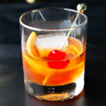 An Old Fashioned Drink recipe served in a glass with a cherry and orange slice garnish