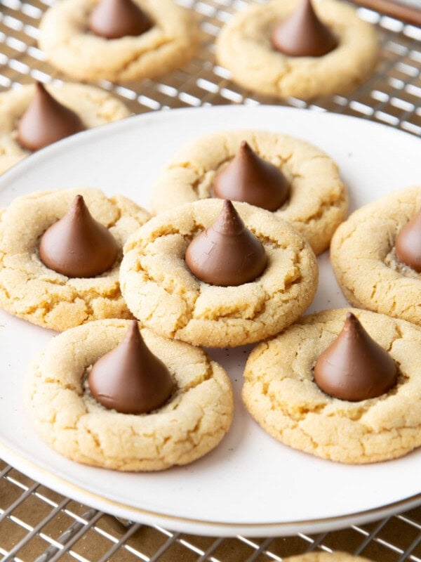 Close up of peanut butter blossoms on in a stack on a white plate