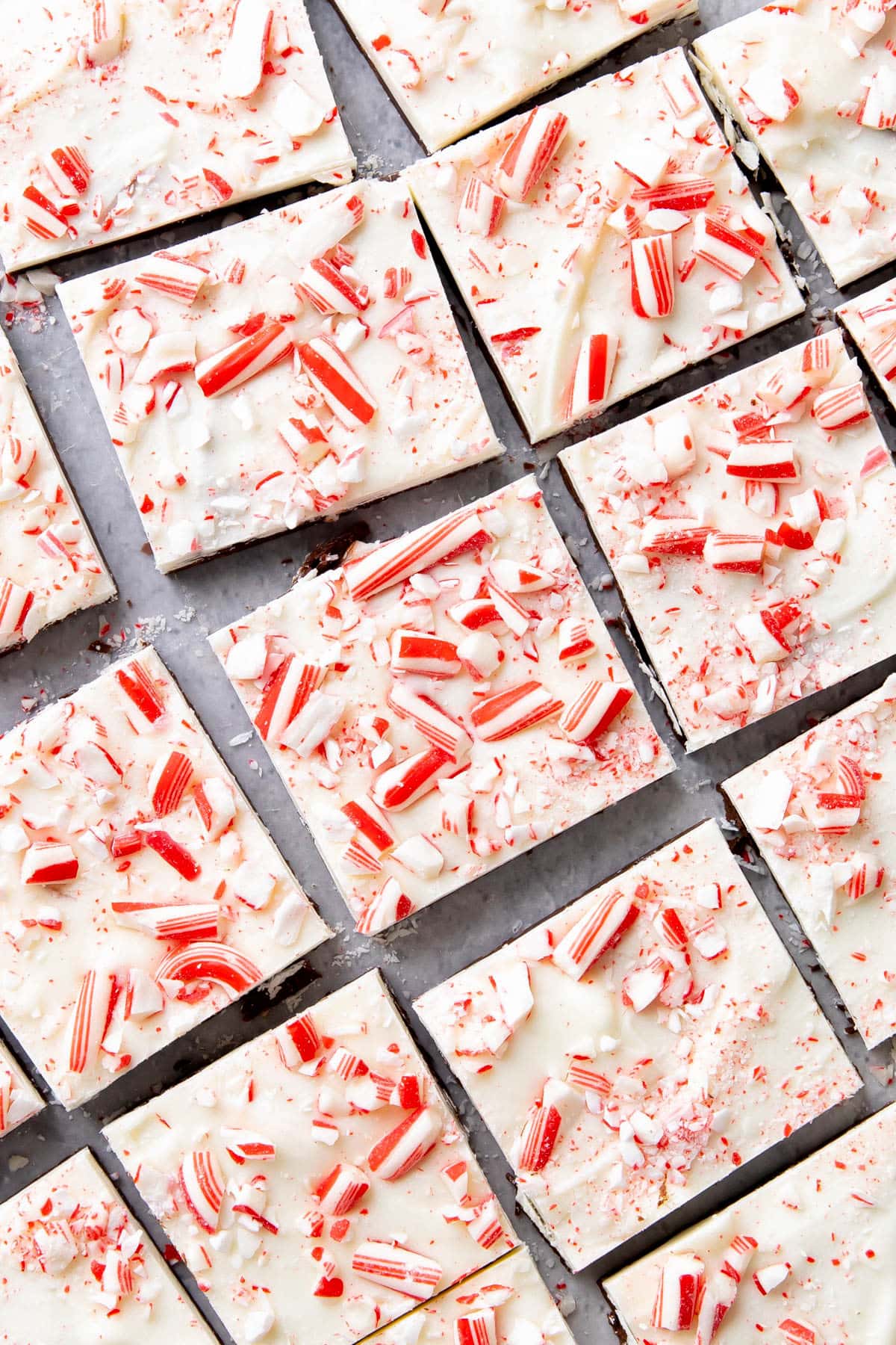 Sliced pieces of peppermint bark on a white wax paper covered counter