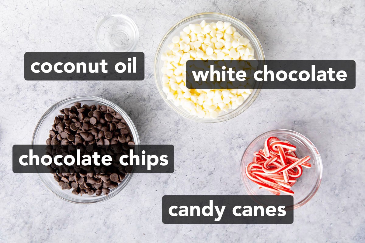 The ingredients for this peppermint bark recipe measured into bowls, including mini candy canes, semi-sweet chocolate and white chocolate morsels and coconut oil.