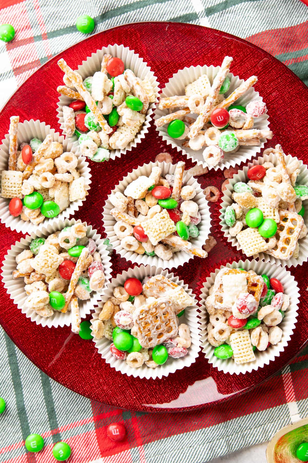 Christmas snack mix in individual cups on a red serving tray