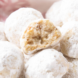 close up of a half bitten snowball cookie to show the tender texture