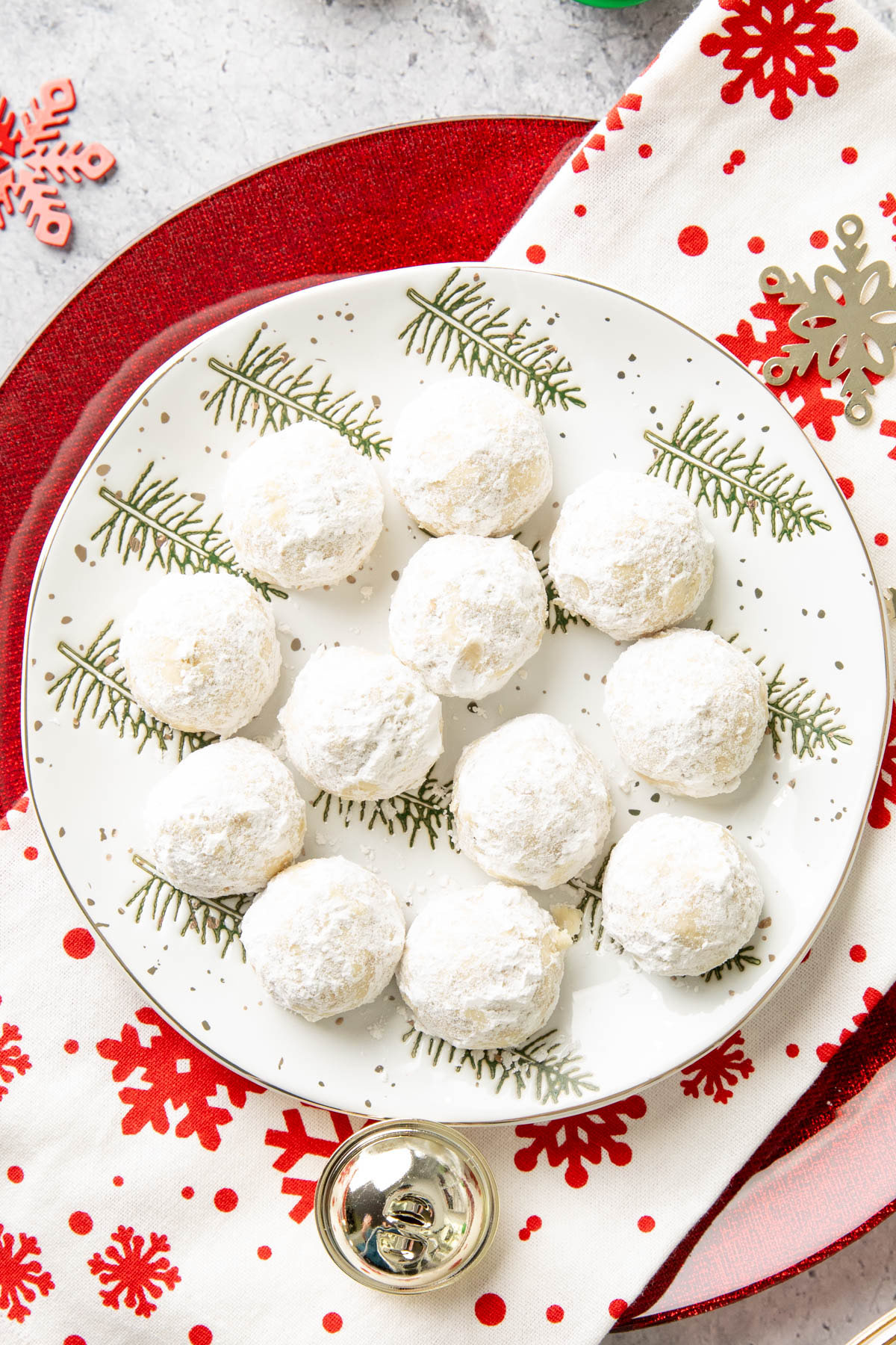 Christmas treats on a tree-lined plate with ornaments and snowflakes