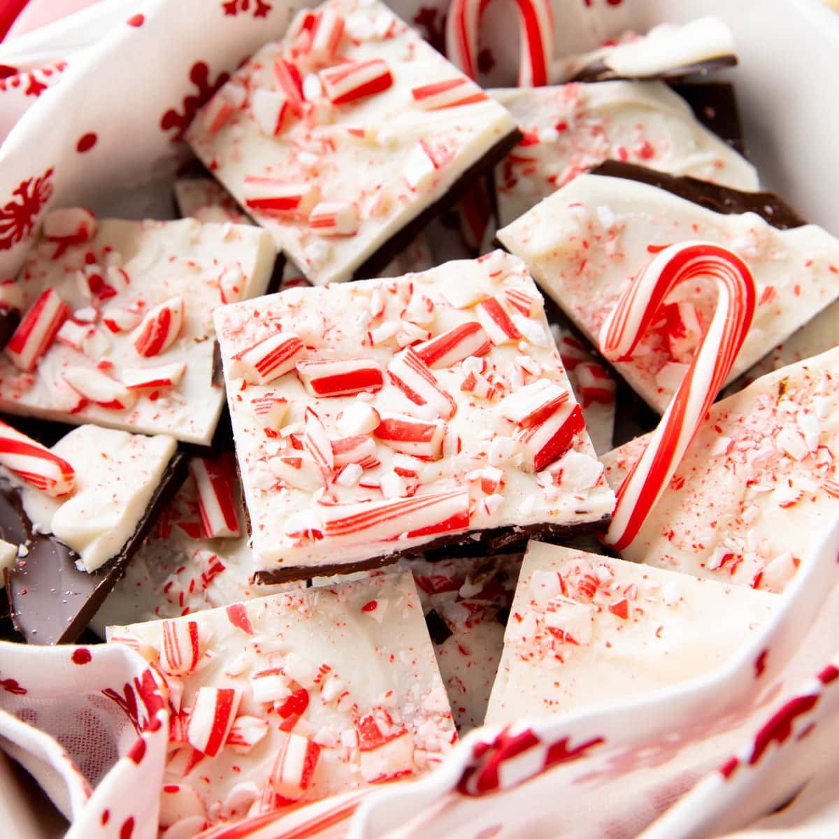 Cascades of peppermint bark pieces in a candy dish with mini candy canes
