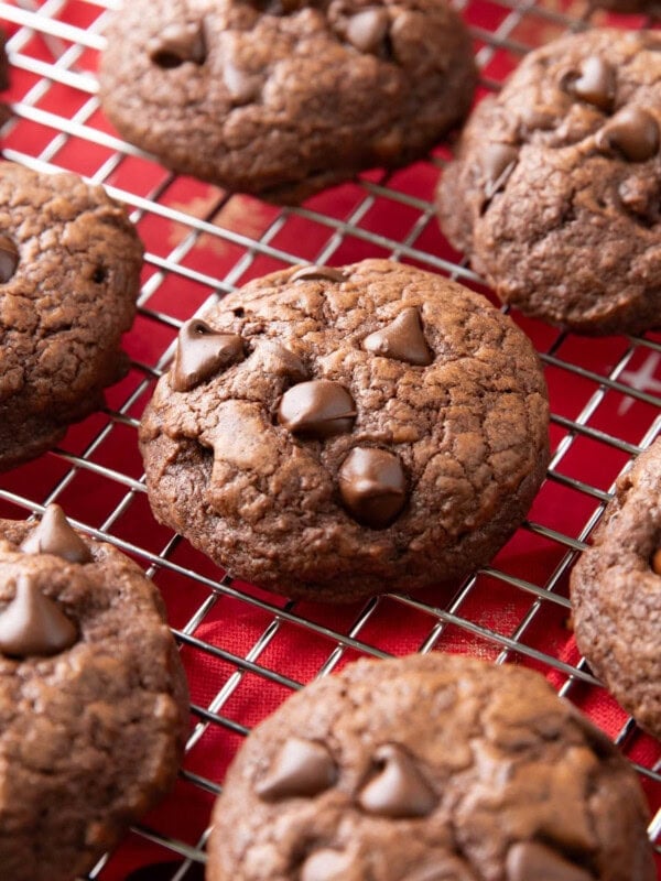 Brownie cookies cooling on a rack with melty chocolate chips on top