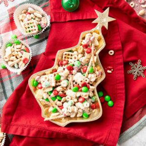 Reindeer Chow in a Christmas tree serving dish topped with red and green M&M's