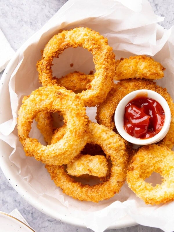 Bowl of Air Fryer Onion Rings served with ketchup.