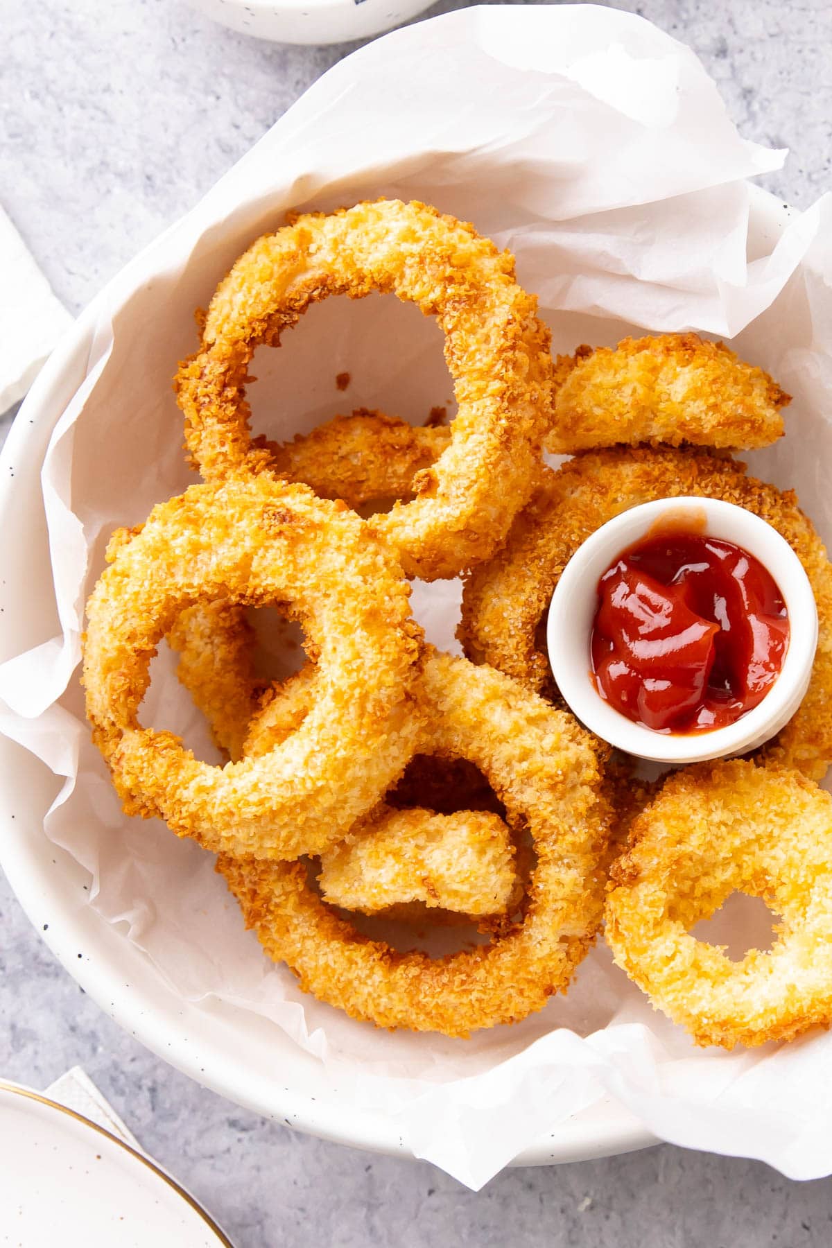 Air Fryer Onion Rings served in a bowl with ketchup