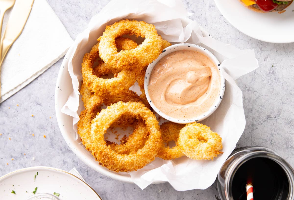 This healthier appetizer made with less oil served up in a basket with a sauce made with mayo, ketchup, Cajun seasoning, and more.