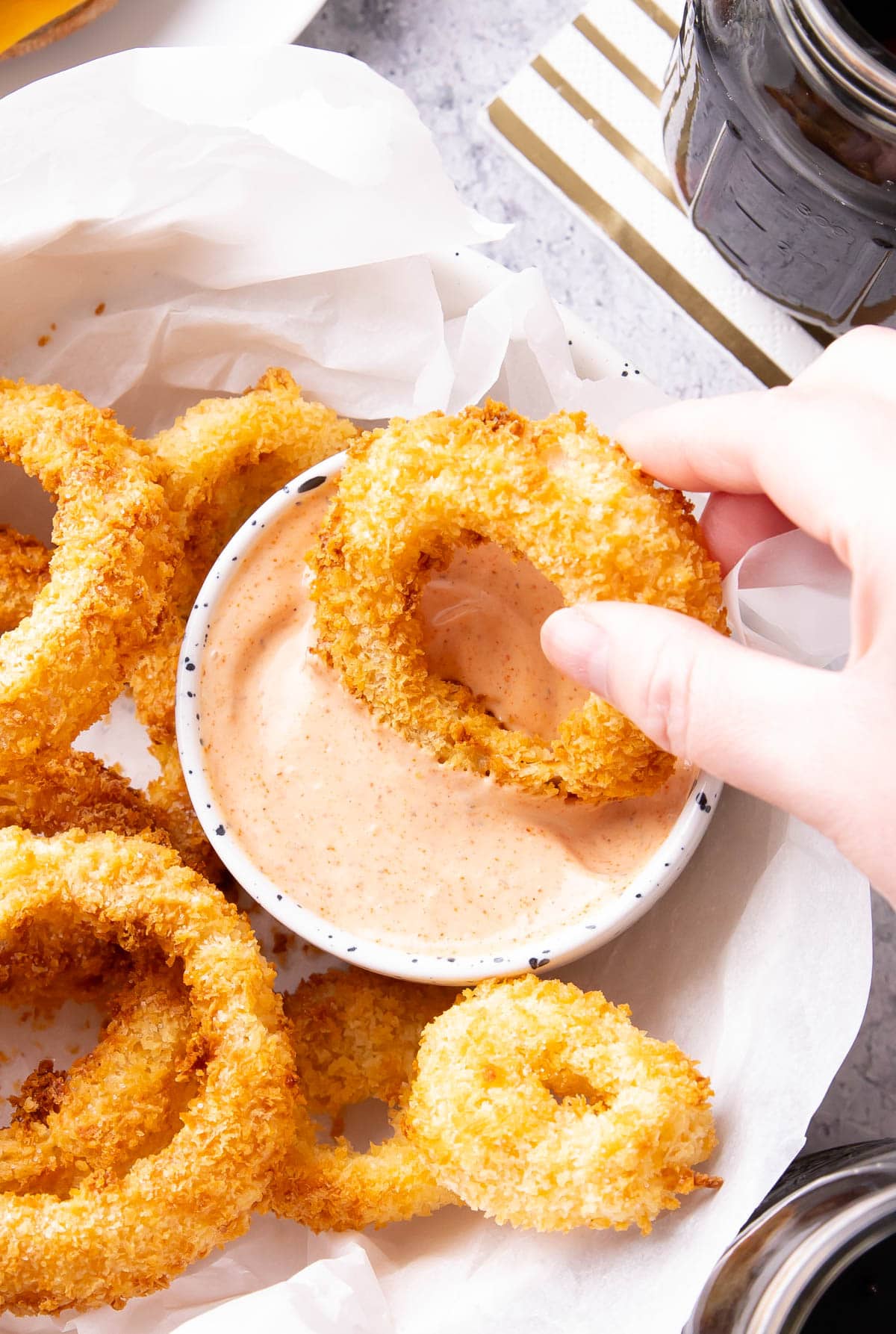 Dipping a golden onion ring into a bowl of this flavorful Onion Ring Sauce