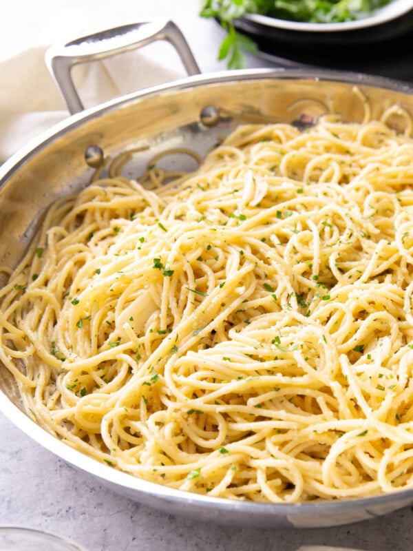 Garlic Butter Pasta in a skillet topped with parmesan and fresh chopped parsley and coated with Garlic Butter Pasta Sauce.