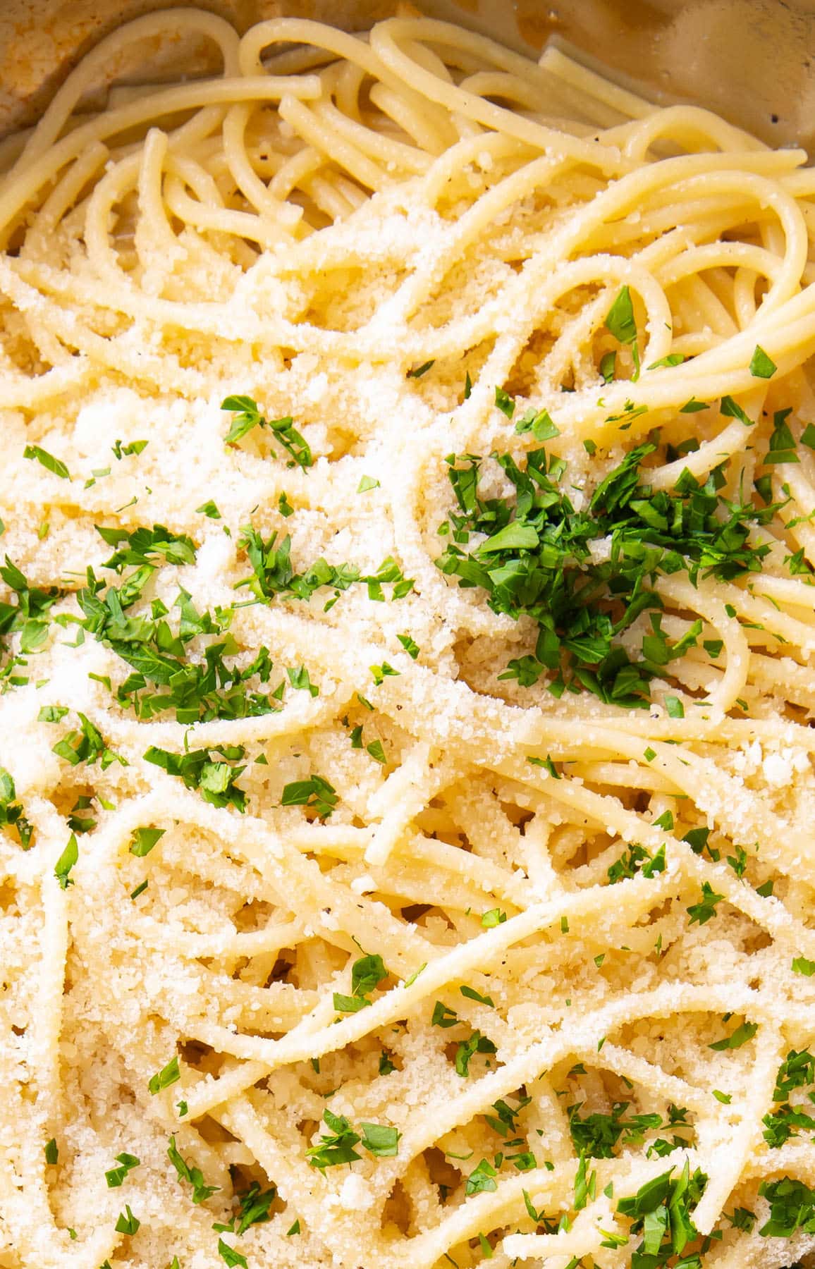 Close up of buttery, perfectly cooked Garlic Butter Pasta topped with parsley and parmesan