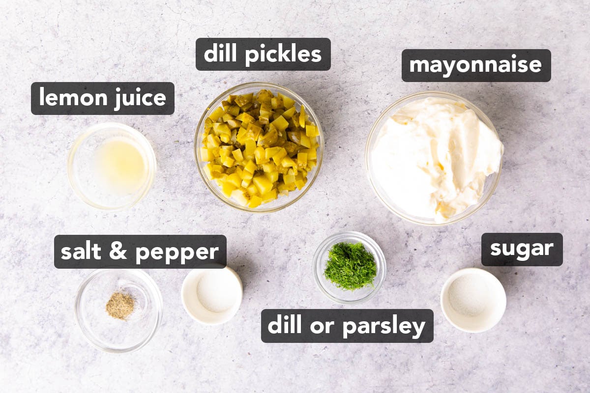Ingredients in this recipe for tartar sauce in prep bowls including finely chopped dill pickles, mayonnaise, lemon juice, dill, sugar, salt, and pepper